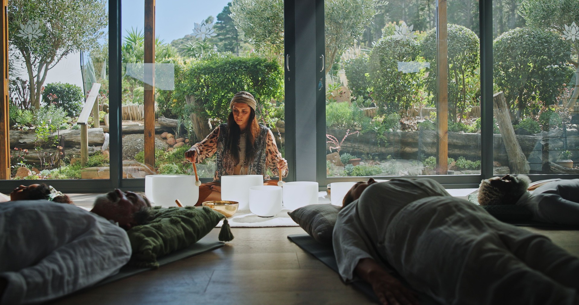 Woman, singing bowl and floor for holistic therapy, frequency and peace with mindfulness at studio. Group, shaman and healing with guide in class, crystal or zen for chakra balance at wellness resort